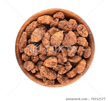 Tigernuts isolated on white background. Chufa nuts or tiger nuts in wooden bowl. Top view. Tigernuts isolated on white background. Chufa nuts or tiger nuts in wooden bowl. Top view. 70552577