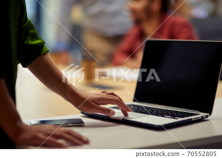 Cropped shot of woman using laptop while standing in the modern office Cropped shot of woman using laptop while standing in the modern office 70552805