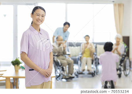 Young female caregiver working at a nursing home Young female caregiver working at a nursing home 70553234