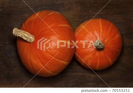 Two pumpkins are on a wooden background 70553251