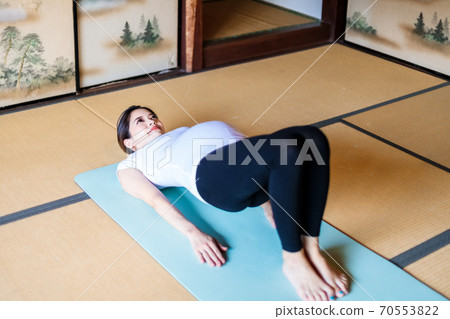 Pregnant woman doing maternity yoga in an old folk house 70553822