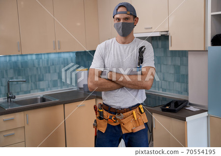 Young caucasian repairman in face mask working with furniture Young caucasian repairman in face mask working with furniture 70554195
