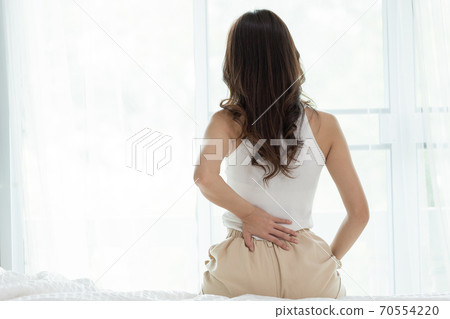 Asian women wake up happy and smile on white bed in bedroom. 70554220