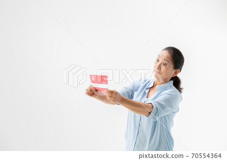 A senior woman surprised to see her passbook 70554364