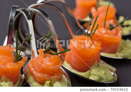 salad of red fish, cold appetizer with salmon and cucumbers on curly spoons salad of red fish, cold appetizer with salmon and cucumbers on curly spoons 70554633