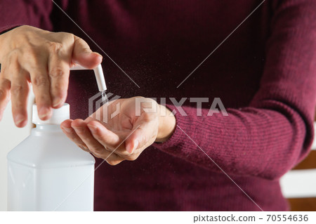 婦女用酒精消毒劑消毒雙手,以預防傳染病 婦女用酒精消毒劑消毒雙手,以預防傳染病 70554636