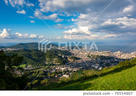 The city of Otaru and the ropeway seen from the observation deck of Mt. Tengu, Ishikari Bay in the background and the blue sky 70554807