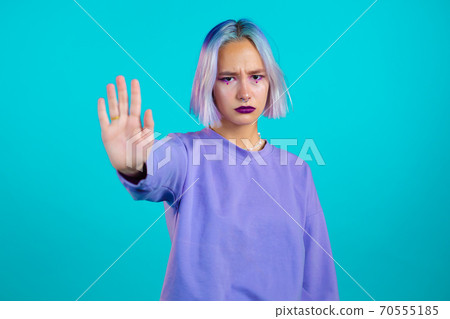 Pretty woman with violet hair disapproving with NO hand sign gesture. Denying, rejecting, disagree Pretty woman with violet hair disapproving with NO hand sign gesture. Denying, rejecting, disagree 70555185