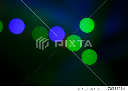Colored light flashes in green and blue tones on black background Colored light flashes in green and blue tones on black background 70555284