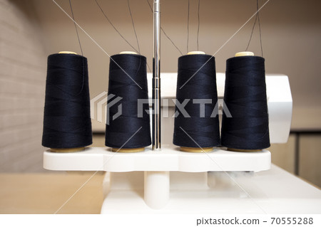 Black thread bobbins on modern overlock white sewing machine, professional sewing machine 70555288