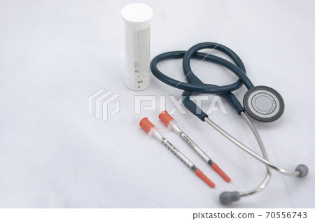 Two syringes with cap, stethoscope and medicine canister on white background 70556743