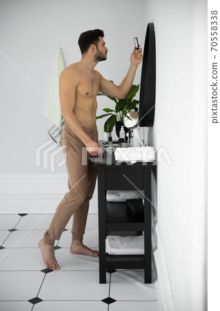 Close up shot of man looking at mirror reflection 70558338