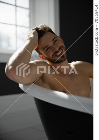Portrait of man taking bath 70558414