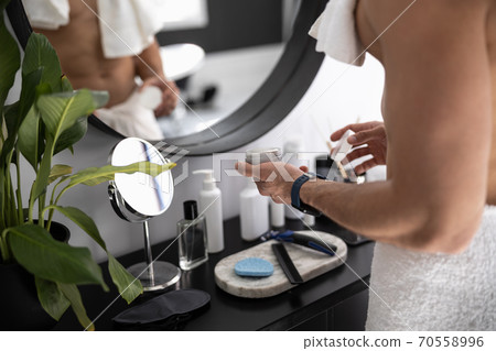 Close up shot of man holding jar of face cream 70558996
