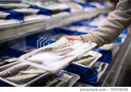 Children's hands picking up fish in a supermarket Children's hands picking up fish in a supermarket 70559098