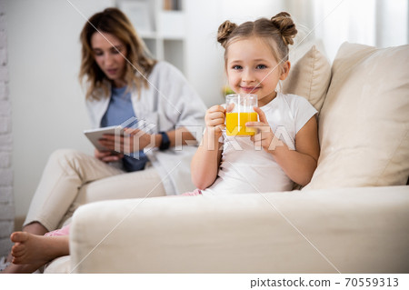 Girl holding orange juice 70559313