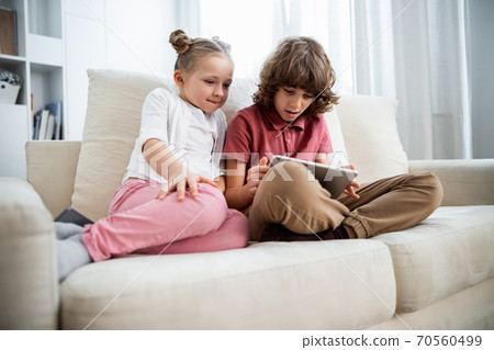 Kids playing at the digital tablet at the sofa 70560499
