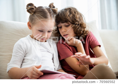 Kids playing game on digital tablet 70560502