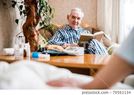 Old man enjoying interesting novel 70561134