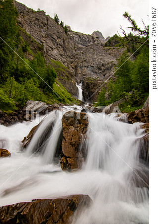 Small waterfalls streaming in green forest in long exposure. water in motion - swiss Alps 70561687