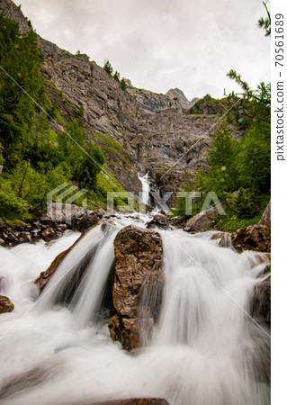 Small waterfalls streaming in green forest in long exposure. water in motion - swiss Alps 70561689