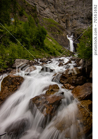Small waterfalls streaming in green forest in long exposure. water in motion - swiss Alps 70561692