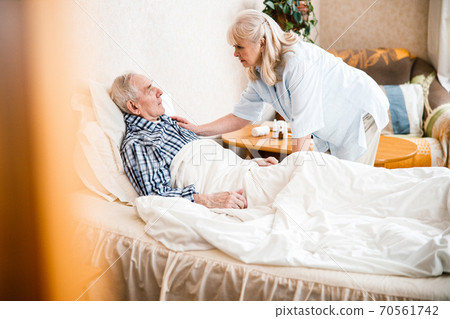 Wife taking care of her ill spouse Wife taking care of her ill spouse 70561742