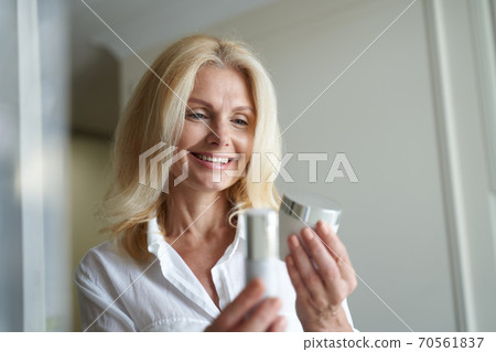 Smiling lady enjoying shopping for skin care products 70561837