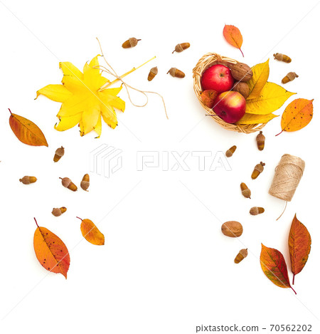 Fall leaves, apple, acorns and twine on white background. Autumnal and thanksgiving concept Fall leaves, apple, acorns and twine on white background. Autumnal and thanksgiving concept 70562202