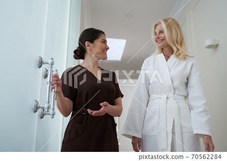 Smiling spa salon worker communicating with a client 70562284
