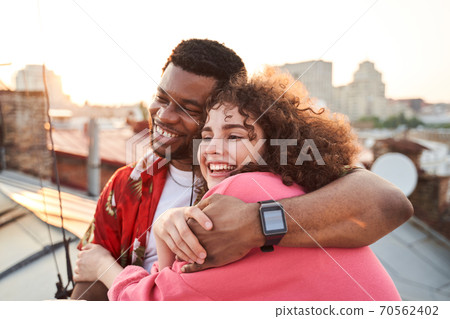 Cheerful attractive couple cuddling at summer sunset 70562402
