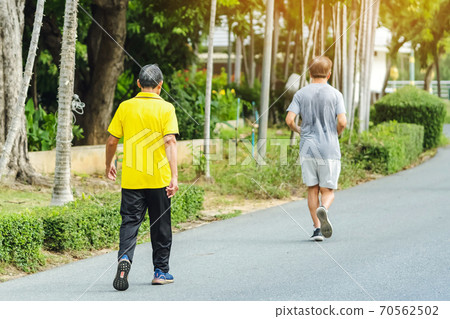 Back view portrait of a Asian elderly man in fitness wear walking and jogging for good health in public park. Senior jogger in nature. Older Man enjoying Peaceful nature. Healthcare concept. Back view portrait of a Asian elderly man in fitness wear walking and jogging for good health in public park. Senior jogger in nature. Older Man enjoying Peaceful nature. Healthcare concept. 70562502