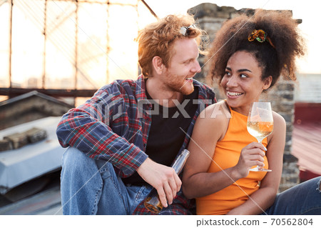Cheerful young couple dating on urban roof Cheerful young couple dating on urban roof 70562804