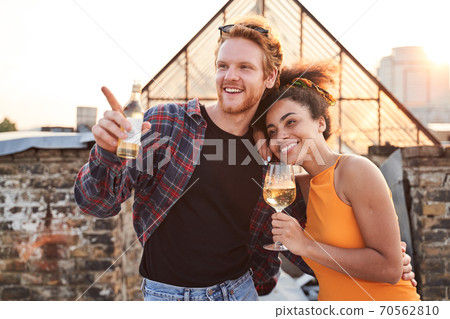 Cheerful young lovers hugging on urban roof Cheerful young lovers hugging on urban roof 70562810