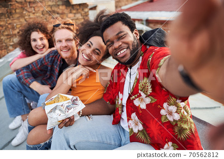 Happy friends relaxing together on urban roof 70562812