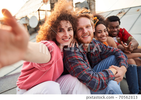 Cheerful friends taking selfie together on roof Cheerful friends taking selfie together on roof 70562813