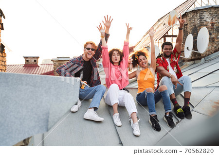 Jolly four friends having fun on roof 70562820