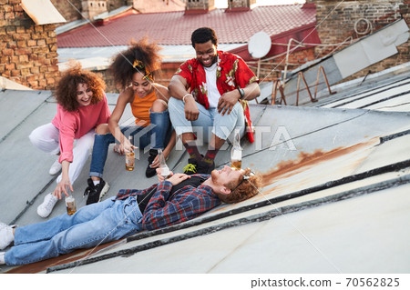 Playful young people spending jolly evening on roof 70562825