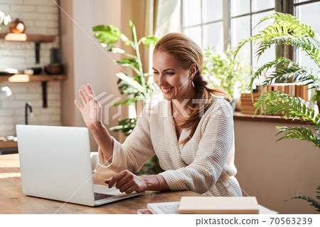 Positive woman enjoying friendly video call at home Positive woman enjoying friendly video call at home 70563239