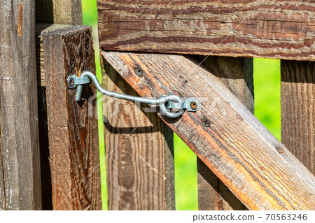 Wooden door locked on a metal hook Wooden door locked on a metal hook 70563246