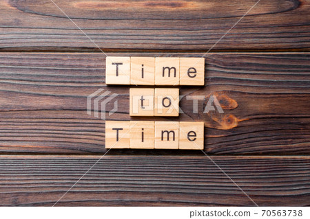 Time to time word written on wood block. Time to time text on cement table for your desing, concept Time to time word written on wood block. Time to time text on cement table for your desing, concept 70563738