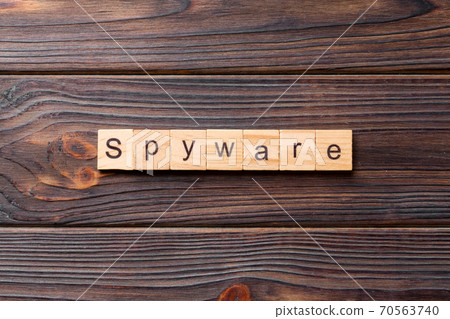 spyware word written on wood block. spyware text on cement table for your desing, concept spyware word written on wood block. spyware text on cement table for your desing, concept 70563740