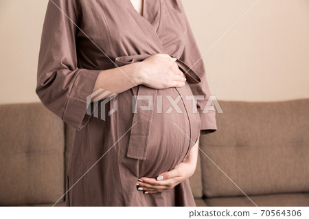 Pregnancy woman in beautiful dress standing on the home 70564306
