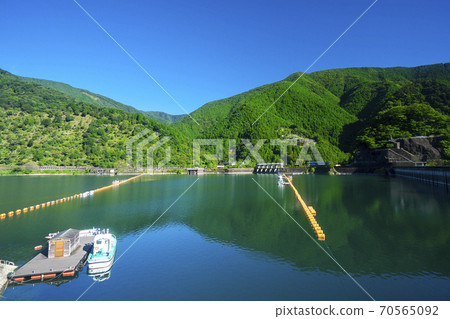 Lake Okutama in summer, from the south shore to the lake surface and the mountains on the north shore Lake Okutama in summer, from the south shore to the lake surface and the mountains on the north shore 70565092