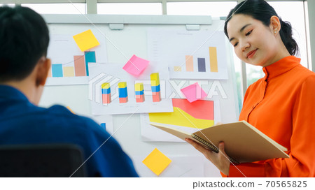 Young woman explains business data on white board 70565825