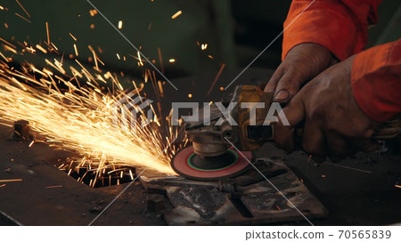 Professional mechanic is cutting steel metal. Professional mechanic is cutting steel metal. 70565839