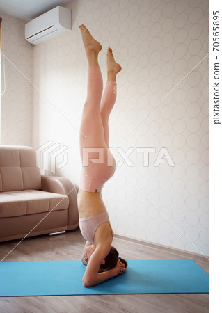 athlete girl is engaged in gymnastics.acrobat home athlete girl is engaged in gymnastics.acrobat home 70565895