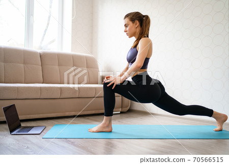 girl is engaged in sports at home, stretching. 70566515