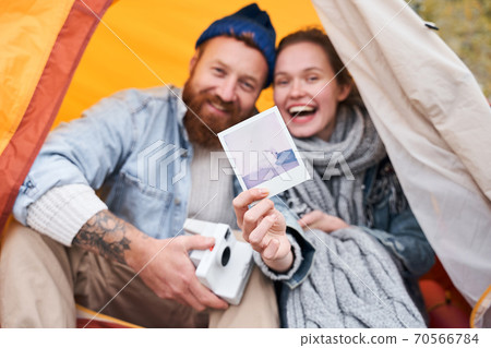 Couple showing photo of their dog Couple showing photo of their dog 70566784