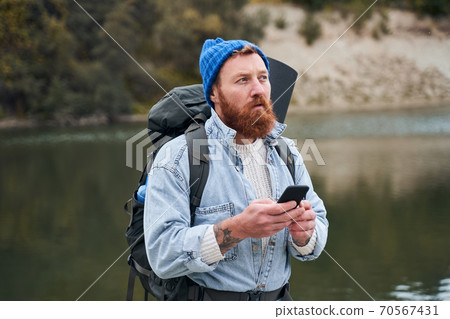 Man with backpack pondering where to go 70567431